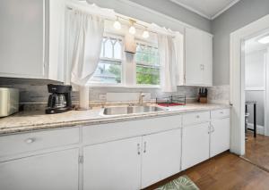 a white kitchen with a sink and a window at Pura Vida, Live Pure! 2 b, 1 b. in Akron