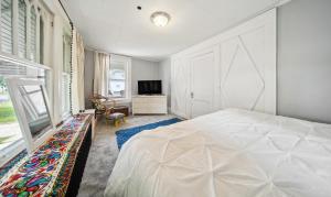 1 dormitorio con 1 cama blanca grande y TV en Pura Vida, Live Pure! 2 b, 1 b., en Akron