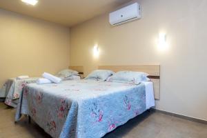 1 dormitorio con 2 camas con sábanas azules y aire acondicionado en Hotel Park Haus, en Nova Petrópolis