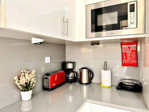 a kitchen counter with a microwave and appliances on it at Lucky Alameda Apartment in Lisbon