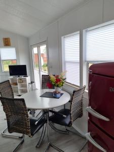 uma sala de jantar com uma mesa branca e cadeiras em Storchenhof Mobilheim 1 em Katzow