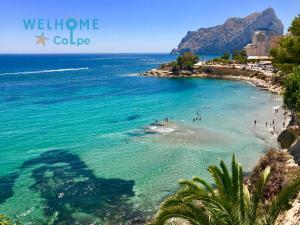 widok plaży z ludźmi w wodzie w obiekcie CALALGA сasa frente a la playa con piscina privada w mieście Calpe