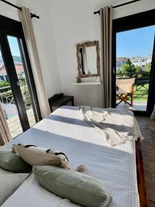 a bedroom with two beds and a balcony at Rania Residence in Skopelos Town