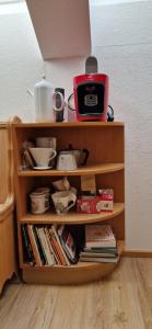 a wooden book shelf with dishes and a toaster on it at Haus zum Kranich, traditionelles, charmantes, ehemaliges Bauerngasthaus in Möggers