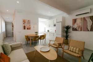 a living room with a table and chairs and a kitchen at Lujoso apartamento con piscina compartida 3 in Seville