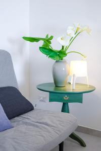 a table with a vase with flowers on it next to a chair at casa Taormina in Letojanni