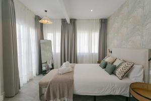 a bedroom with a large white bed with pillows at Lujoso apartamento con piscina compartida 3 in Seville