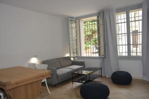 un soggiorno con un divano e un tavolo di Maison Rascas - Centre historique - Air conditioning- wifi ad Avignone