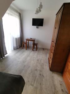 uma sala de estar com uma televisão e uma mesa em Noclegi na Wygonie em Sromowce Niżne