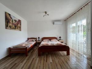 a bedroom with two beds and a window at Apartment Kovach Kuti in Herceg-Novi