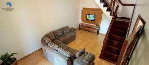 uma sala de estar com um sofá e uma televisão em Casa Familiar com Piscina e Churrasqueira em Foz do Iguaçu