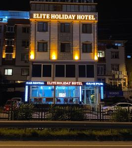 a building with a blue holiday hotel at night at Elite Holiday Hotel in Trabzon