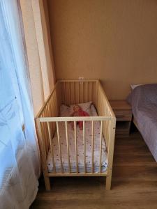 a crib with a teddy bear in it in a bedroom at SMILE in Ventspils