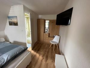 ein Schlafzimmer mit einem Bett und einem TV an der Wand in der Unterkunft Gästehaus Bremer in Cuxhaven