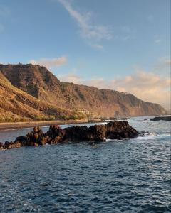 a body of water with a beach and a mountain at Vistas al Mar in Tacoronte