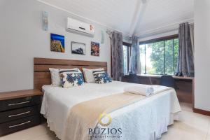 Un dormitorio con una cama grande y una ventana. en ¡Bz 51 Centro! Alto estándar, 4 Suites con/ Zona de ocio privada, en Búzios 37 fotos más