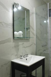 y baño con lavabo, espejo y ducha. en HL Hotel en Cipolletti