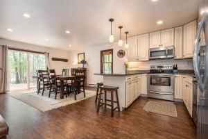 a kitchen with white cabinets and a table and chairs at Bear Trap in Swanton