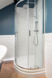 a shower with a glass door in a bathroom at Beautiful 2-Bed Cottage in Brampton in Brampton