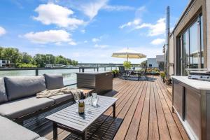 a patio with a couch and a table on a deck at THE ROOT your charming floating home in Bratislava