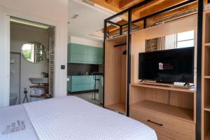 a bedroom with a bed and a flat screen tv at Apartamentos Turísticos Casa Arango in Ribadeo