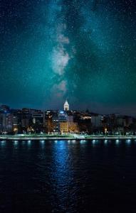 伊斯坦堡的住宿－Astra Boutique Hotel，夜空在水面上,满天星空的城市