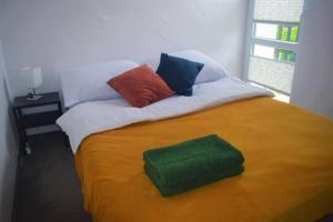 a bed with colorful pillows on top of it at Dobre Wakacje, 8 km od Mielna i od Koszalina in Będzino