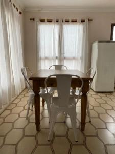 una mesa y 2 sillas en una cocina con nevera en Villegas Centro en Coronel Suárez