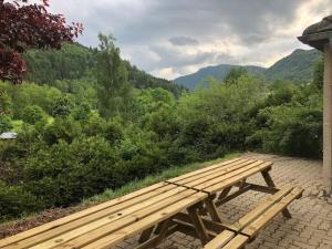 eine Holzbank auf einem gemauerten Gehweg mit Aussicht in der Unterkunft maison individuelle in Laveissière
