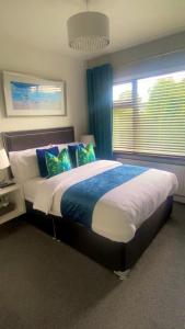 een slaapkamer met een groot bed met blauwe en witte kussens bij Robin Hill Bed and Breakfast in Curracloe