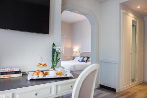 Un dormitorio con una cama y una mesa con fruta. en Parco dei Principi Boutique Hotel, en Rímini