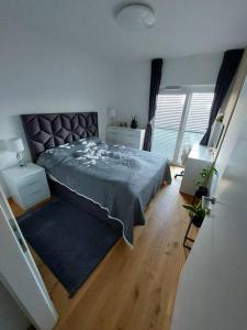 sypialnia z dużym łóżkiem i drewnianą podłogą w obiekcie Luxury Apartment Ljubljana w Lublanie