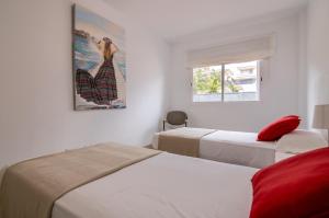 sypialnia z 2 łóżkami i obrazem na ścianie w obiekcie Oasis del Mar w mieście Puerto de Santiago
