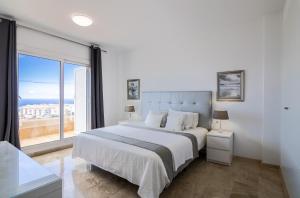 a bedroom with a large bed and a large window at Oasis del Mar in Puerto de Santiago