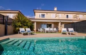 a villa with a swimming pool and a house at Oasis del Mar in Puerto de Santiago