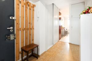 a hallway with a door and a wooden stool at SuperApart Inflancka 19 ROOMS in Warsaw
