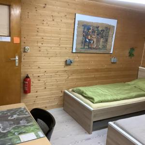 a bedroom with a bed and a wooden wall at Gemütliches Zimmer im Seterant/Untergeschoss in Essen