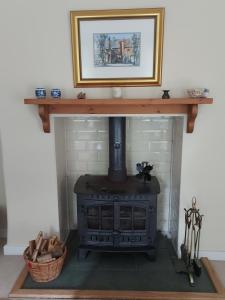 una chimenea con estufa de leña en una habitación en ISLAY House,Comfortable Home with private garden, Pencaitland, East Lothian, Scotland en Pencaitland