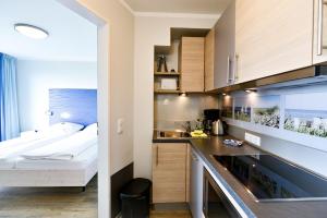 a small room with a bed and a kitchen at Beach Lodge BL04 in Cuxhaven