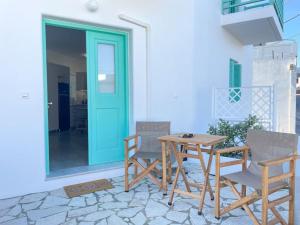 a table and chairs on a patio with a blue door at Just Live in Triovasálos