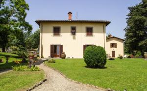 una gran casa blanca con un patio de césped en Il Vago Soggiorno en Barberino di Mugello