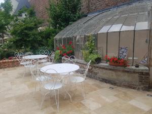 a group of tables and chairs in front of a greenhouse at Le Clos Saint-Germain in Rugles
