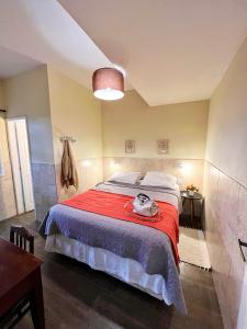 1 dormitorio con 1 cama grande con manta roja en Suítes no centro histórico, en Petrópolis