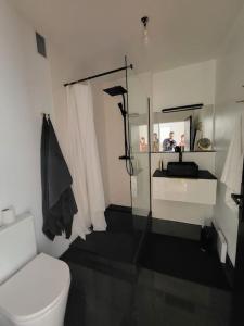 a bathroom with a white toilet and a sink at Superbe T3 lumineux sur parc arboré avec piscine in Anglet