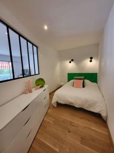 a bedroom with a bed and a large window at Superbe T3 lumineux sur parc arboré avec piscine in Anglet +4 photos