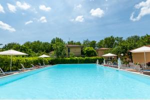 uma grande piscina com cadeiras e guarda-sóis em Loriana Park Hotel Sul Lago em Bolsena