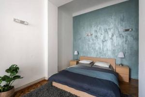1 dormitorio con cama y pared azul en Spacious apartment with balcony at Wenceslas Sq, en Praga