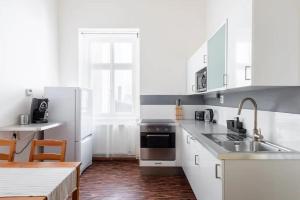 cocina con electrodomésticos blancos y suelo de madera en Spacious apartment with balcony at Wenceslas Sq, en Praga