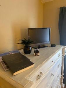 a dresser with a television and a book on it at Locanda Granducato in Chiusi
