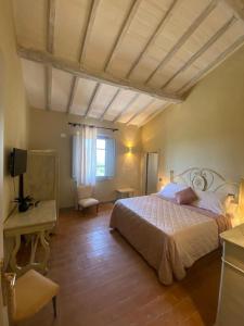 a bedroom with a bed and a table and a window at Locanda Granducato in Chiusi